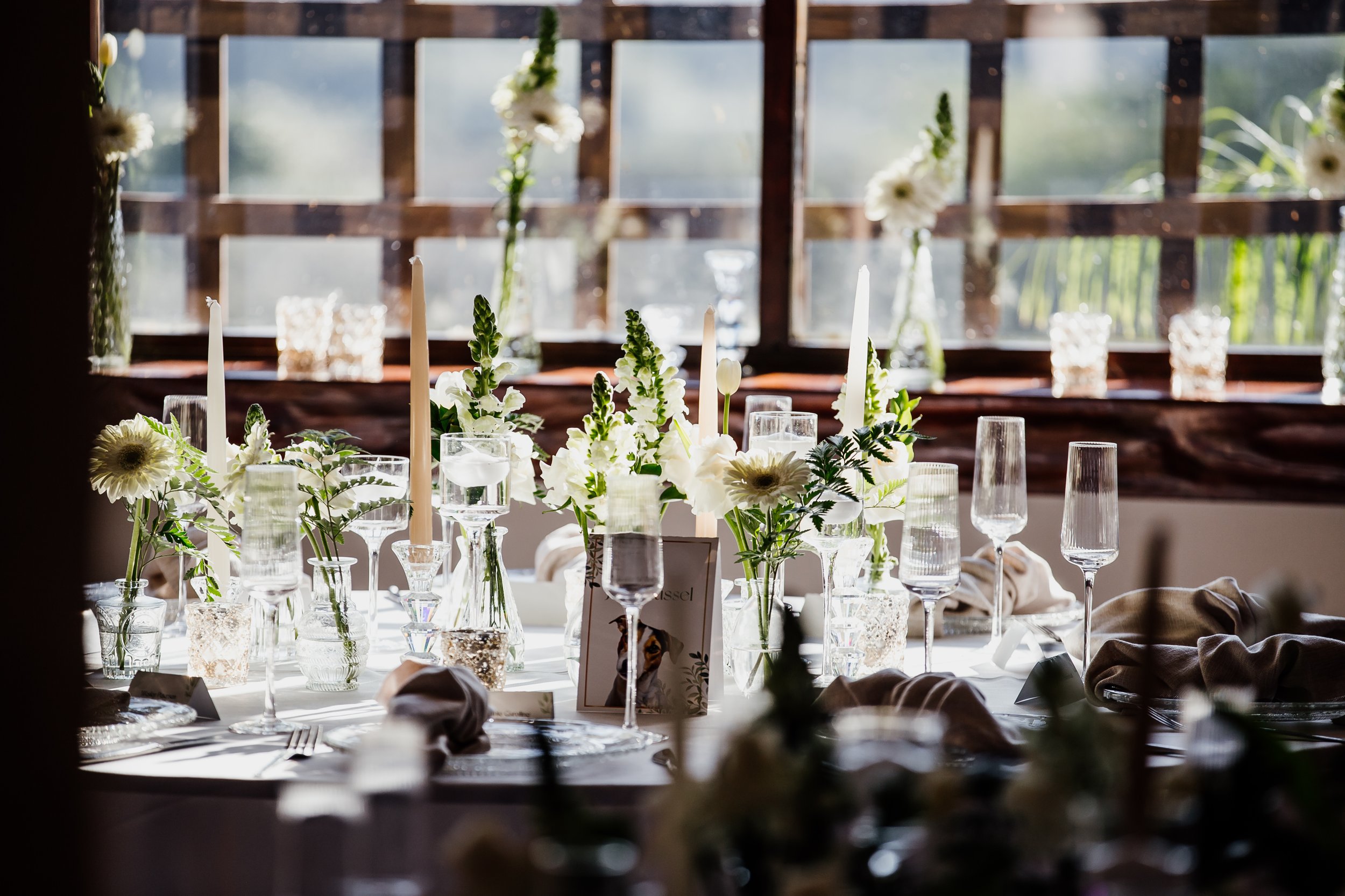 A refined wedding table styled with white florals and candlelight